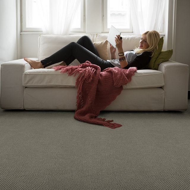 woman laying on sofa with salmon colored blanket from Green Carpet Co. - The Flooring Connection in San Antonio