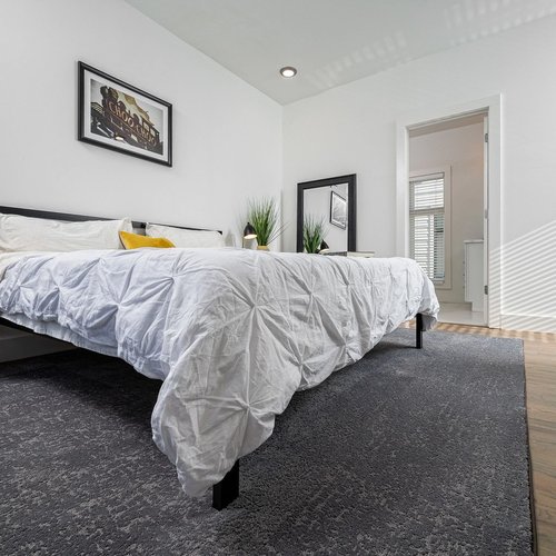 white bed on gray carpet by Green Carpet Co. - The Flooring Connection in San Antonio, TX