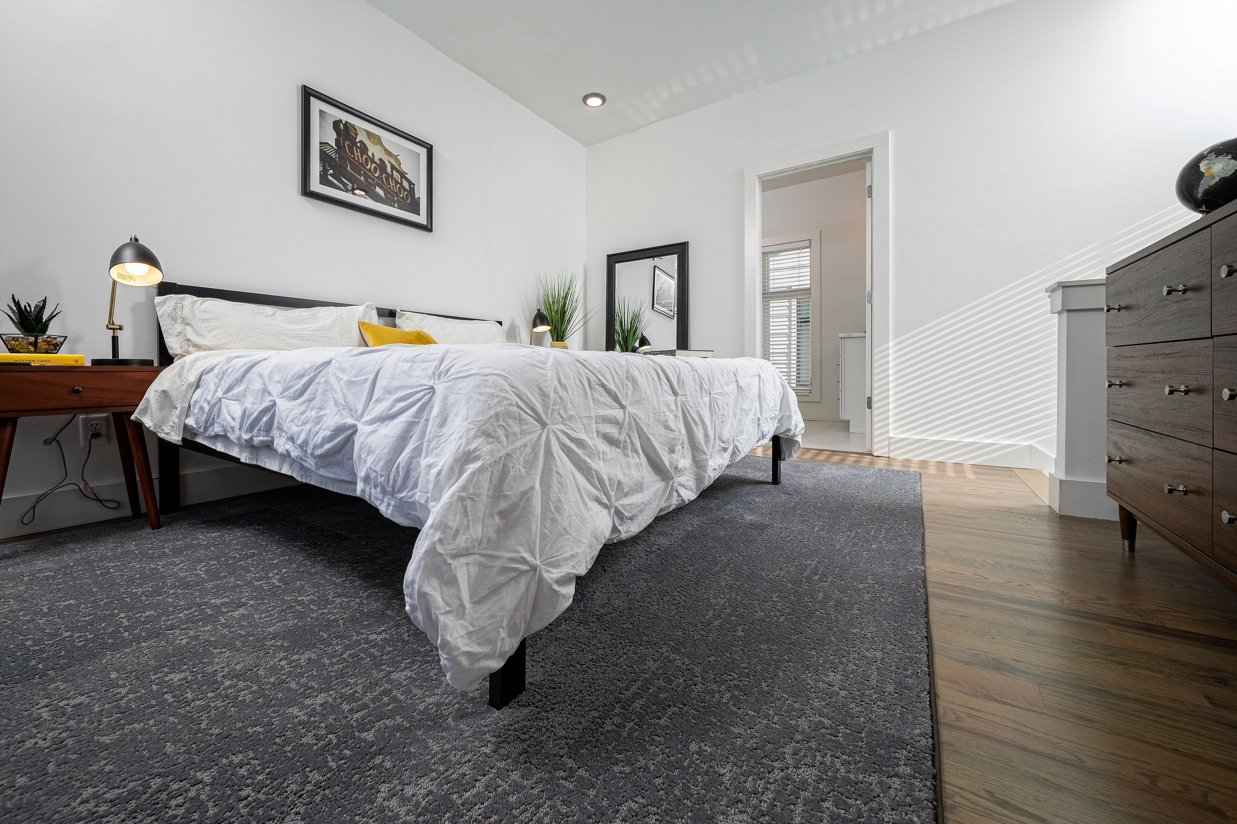 white bed on grey carpet in bedroom from Green Carpet Co. - The Flooring Connection in San Antonio
